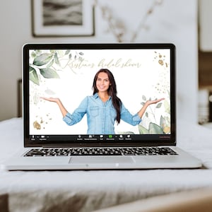 May include: A laptop screen displaying a virtual bridal shower with a woman in a blue shirt and the text "Kristinas Bridal Shower" on a white background with green and gold floral accents.