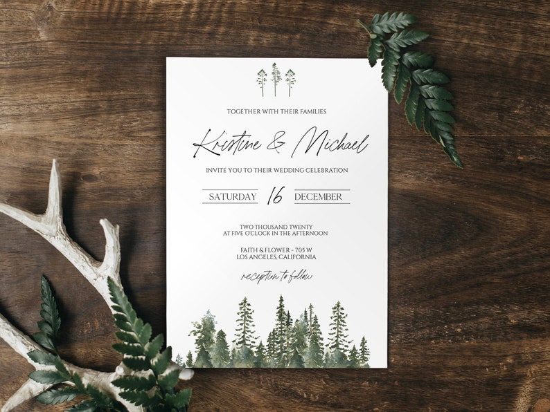 Winter wedding invitation template with forest trees on a wood table