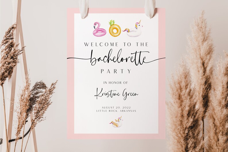 May include: A white sign with a pink border announcing a hen party for Kristine Green on 20 August 2022 in Little Rock, Arkansas. The sign features illustrations of inflatable pool floats, including a flamingo, pineapple, and unicorn.