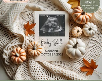 Könnte beinhalten: Eine rechteckige Ankündigungskarte mit einem schwarz-weißen Ultraschallbild, dem Text Baby Smith und dem Datum ARRIVING OCTOBER 2025. Die Karte ist umgeben von kleinen weißen und orangefarbenen Kürbissen und herbstlichen Blättern auf einer cremefarbenen Strickdecke.