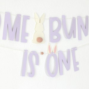May include: Purple banner with the words "Some Bunny is One" and bunny cutouts. The banner is strung with white string.