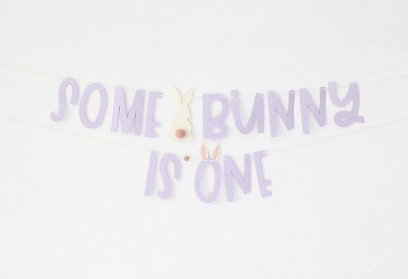 May include: Purple banner with the text "Some Bunny is One" and a white bunny cutout with pink ears.