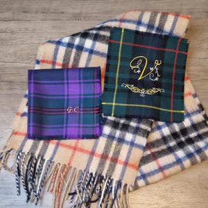 以下が含まれることがあります： フリンジ付きのチェック柄のスカーフが2枚。1枚は黒と白のストライプが入ったベージュのスカーフ。もう1枚は黄と黒のストライプが入った緑のスカーフ。両方のスカーフにはイニシャルが刺繍されている。