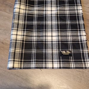 May include: Black and white plaid fabric with a small black label that reads "Art et Mode Creations".