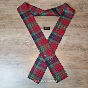 May include: A red, green, and navy blue plaid scarf with yellow accents. The scarf is embroidered with the initials "G & S" and the date "31.10.25". The text "Art et Mode Creations" is also visible.