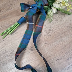 May include: A bouquet of white flowers tied with a blue, green, and red plaid ribbon.