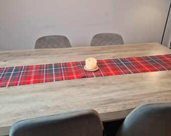 May include: A wooden dining table with a red, green, and white plaid table runner. A lit candle sits on a small wooden coaster in the center of the runner. The text "Art et Mode Creations" is at the bottom.