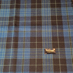May include: Blue and brown plaid fabric with a label that reads "Art et Mode Creations".