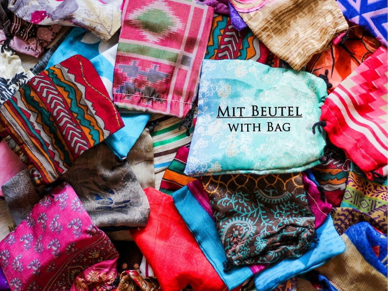 May include: A pile of colorful fabric squares with various patterns. The fabric squares are arranged in a random order. The text "MIT BEUTEL WITH BAG" is printed on a light blue fabric square.