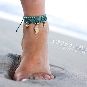 May include: A turquoise and gold ankle bracelet with leaf charms. The bracelet is made with macrame and brass beads. The text "PERLEN AUS MESSING BRASS BEATS" is visible in the image.