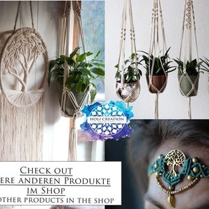 May include: A macrame wall hanging with a tree of life design. The hanging is made of natural colored cord and has a fringe at the bottom. The image also shows a macrame plant hanger with a green plant in a brown pot. The text "CHECK OUT UNSERE ANDEREN PRODUKTE IM SHOP OUR OTHER PRODUCTS IN THE SHOP" is at the bottom of the image.