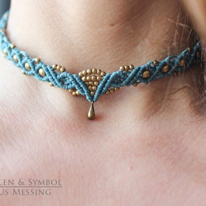 May include: A teal blue and gold macrame choker necklace with a small teardrop pendant. The necklace is made with a knotting technique and features small gold beads.