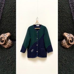 May include: A dark green and navy blue fleece jacket with a button closure and decorative ram's head buttons.