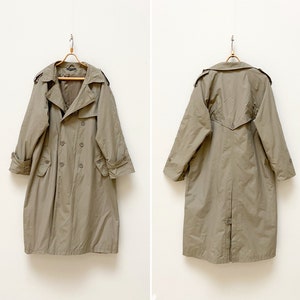 May include: A beige trench coat with a double-breasted closure and a belt. The coat has a classic design and is perfect for layering in the fall or spring.