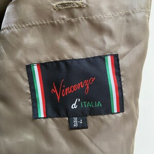 May include: A brown jacket with a black label that says "Vincenzo d'ITALIA" and a size tag that says "38-4 46".
