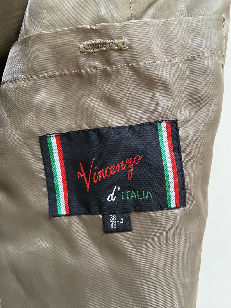 May include: A brown jacket with a black label that says "Vincenzo d'ITALIA" and a size tag that says "38-4 46".