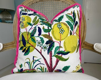 May include: A white pillow with a pink border features a colorful floral pattern with yellow lemons and green leaves.