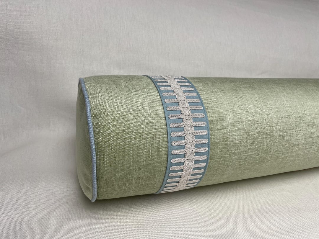 Kravet Poet Plain Leaf chenille bolster with Schumacher Castille tape in sky.