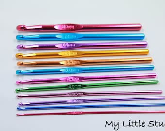 May include: A collection of colorful crochet hooks in various sizes, arranged on a white surface. The hooks are metallic with sizes ranging from 2.0mm to 6.5mm. The colors include pink, blue, purple, gold, and green. The text "My Little Studio" is in the bottom right corner.