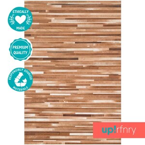 May include: A brown and beige striped rug made from ethically sourced leather. The rug is made with premium quality materials and is responsibly sourced.