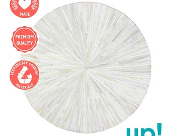 May include: White round rug made from ethically sourced leather. The rug has a radial pattern with strips of leather radiating from the center.