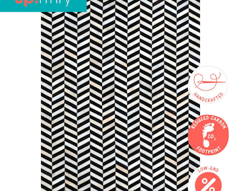 May include: Black and white chevron patterned rug with a handmade, reduced carbon footprint, and low-end prices label.