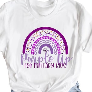 May include: White t-shirt with a purple rainbow design and the text "Purple Up for Military Kids".