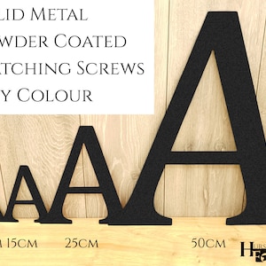 May include: Four black metal letters spelling out the letter "A" in different sizes. The letters are powder coated and are shown on a wooden surface. The letters are 10 cm, 15 cm, 25 cm, and 50 cm in size.