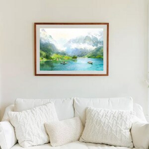 May include: A framed watercolor painting of a lake surrounded by mountains. The lake is a bright blue and the mountains are green and white. There are small boats on the lake.