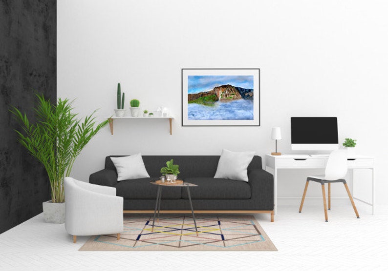 May include: A living room interior design with a black sofa, a white armchair, a white desk with a computer monitor, a white shelf with plants, and a framed landscape photograph of a mountain range with clouds.