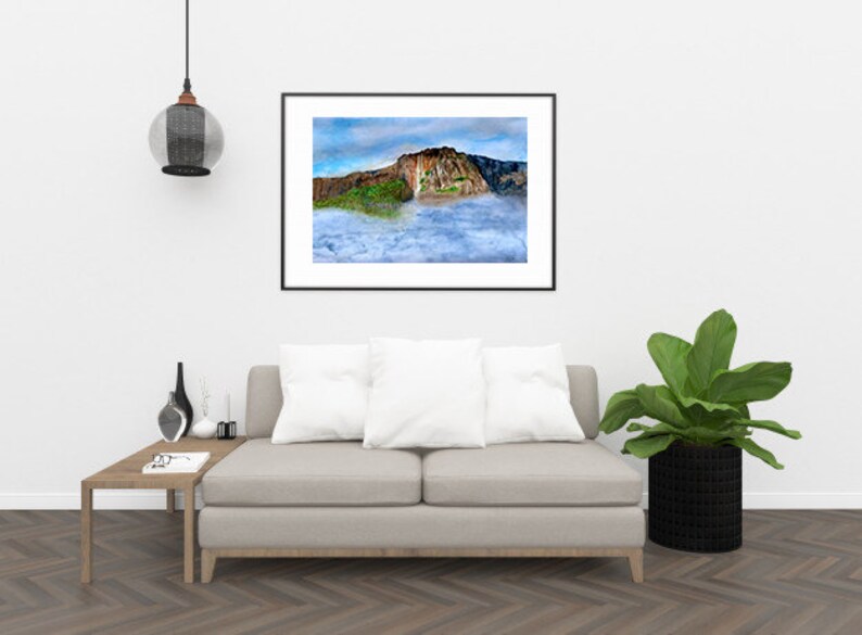 May include: A framed photograph of a mountain peak with clouds in the foreground. The mountain is brown and green with a waterfall cascading down the side. The clouds are white and fluffy.