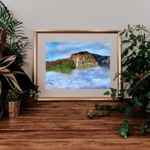 May include: A watercolor painting of a mountain peak with a waterfall cascading down the side. The mountain is surrounded by clouds and a blue sky.