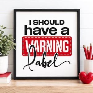 Könnte beinhalten: Ein quadratisches Wandbild mit schwarzem Rahmen und dem schwarzen Text I SHOULD have a auf weißem Hintergrund. Darunter steht das Wort WARNING in weißer Schrift in einem roten Rechteck, gefolgt von dem Wort label in schwarzer Schreibschrift.