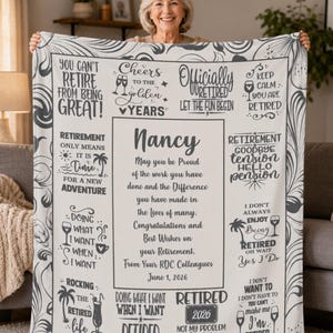 May include: A personalized retirement blanket in cream and gray, held by a smiling woman. The blanket features text and graphics celebrating retirement, including the name "Nancy" and the date "June 1, 2026."