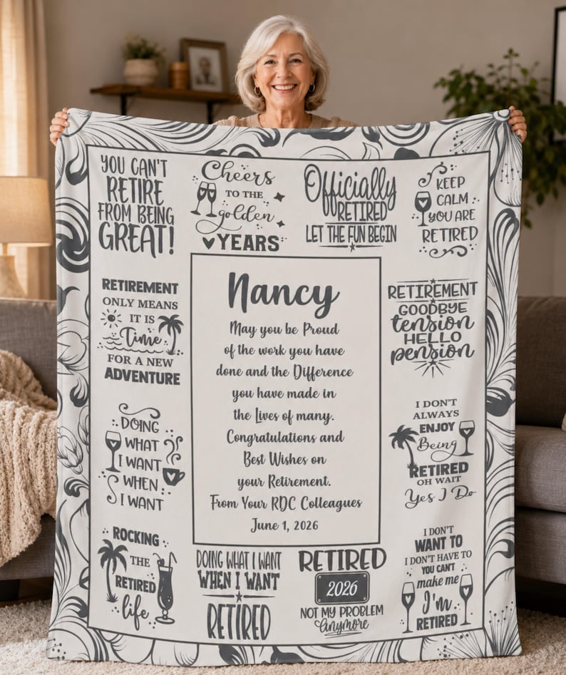 May include: A personalized retirement blanket in cream and gray, held by a smiling woman. The blanket features text and graphics celebrating retirement, including the name "Nancy" and the date "June 1, 2026."