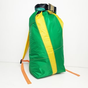 Könnte beinhalten: Ein wasserdichter Rucksack in Grün und Gelb mit orangenen Trägern und einer schwarzen Schnalle.