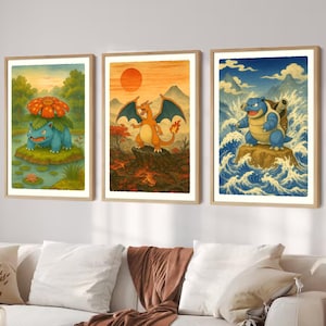 Puede incluir: Conjunto de tres l&aacute;minas art&iacute;sticas enmarcadas con personajes de Pok&eacute;mon. Las l&aacute;minas muestran un Pok&eacute;mon azul y verde en un estanque, un Pok&eacute;mon naranja con alas y un Pok&eacute;mon azul en el oc&eacute;ano. Cada l&aacute;mina tiene un marco de madera.