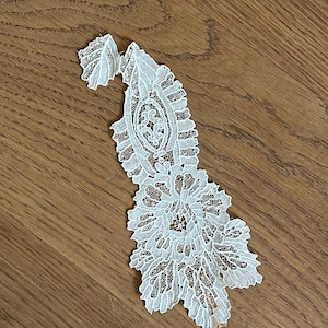 Puede incluir: Aplicación de encaje color marfil con diseño floral y paisley. El delicado encaje presenta intrincados patrones y un borde festoneado. Adecuado para diversos proyectos de manualidades, como ropa de novia y decoración del hogar.
