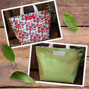 May include: A white tote bag with a strawberry and blueberry print. The bag has a green polka dot lining and a red label that says "A Dolla Mama".