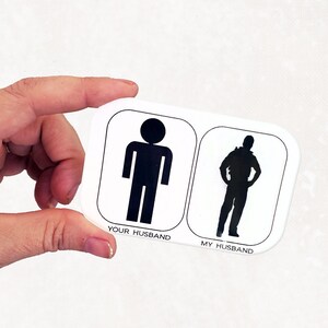 May include: White card with black stick figures of two men. The text on the card reads "Your Husband" and "My Husband".