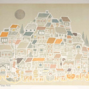 May include: A colorful illustration of a town with houses in various shades of blue, green, orange, and brown. The houses are clustered together on a hill, with a large, gray moon in the sky above. The illustration is done in a whimsical style, with simple lines and shapes.
