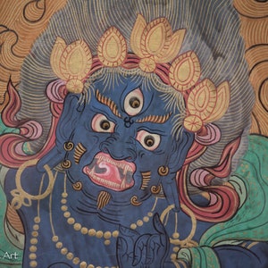 May include: A blue deity with a fierce expression, three eyes, and a large mouth with sharp teeth. The deity is adorned with a crown of golden lotus flowers and a necklace of pearls. The background is a swirling pattern of gold and red.
