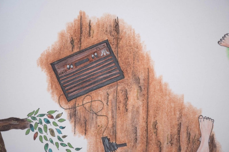 Puede incluir: Una consola de videojuegos vintage marr&oacute;n y negra con un cable que cuelga. La consola est&aacute; colgada en una pared marr&oacute;n con una rama de &aacute;rbol y hojas en primer plano.