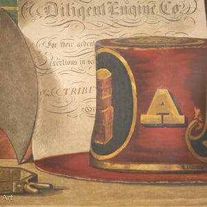 K&ouml;nnte beinhalten: Eine Vintage-Illustration eines roten und goldenen Feuerwehrhelms mit den Worten "Diligent Engine Co." und "MECHAN" an der Seite. Der Helm steht auf einer Holzoberfl&auml;che mit einem St&uuml;ck Papier dahinter.