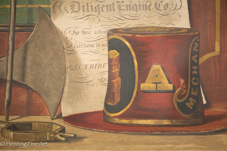 K&ouml;nnte beinhalten: Eine Vintage-Illustration eines roten und goldenen Feuerwehrhelms mit den Worten "Diligent Engine Co." und "MECHAN" an der Seite. Der Helm steht auf einer Holzoberfl&auml;che mit einem St&uuml;ck Papier dahinter.
