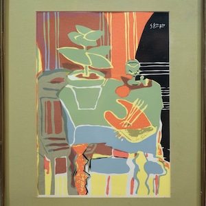May include: A framed abstract print with a green plant, a vase, and a table in a stylized design. The print is in shades of green, orange, yellow, blue, and black. The artist's signature, "Braque", is in the upper right corner.