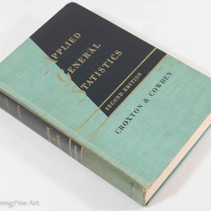 May include: A teal blue hardcover book with gold lettering titled "Applied General Statistics" by Croxton & Cowden. The book is a second edition.
