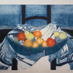 May include: A blue and white patterned tablecloth with a bowl of fruit. The bowl contains oranges, lemons, and a banana. The fruit is arranged in a still life composition.