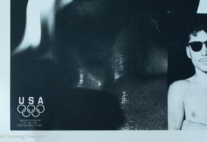 May include: Monochrome poster showing a man in sunglasses. The USA Olympic rings logo is in the lower left corner. The poster is a promotional item for the 1992 US Olympic Team.