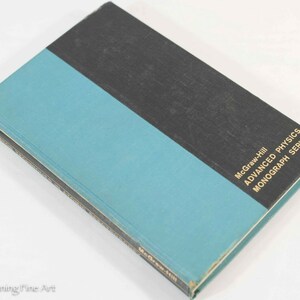 May include: A vintage book with a teal and black cover. The top half of the cover is black, and the bottom half is teal. The book is part of the McGraw-Hill Advanced Physics Monograph Series.